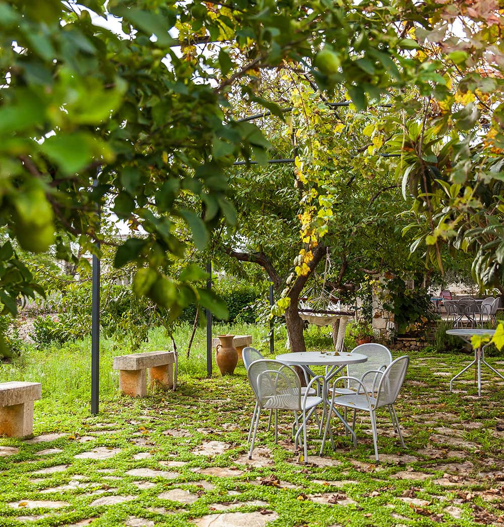 Angolo del Giardino dell'Agriturismo con Tavolini e Sedie