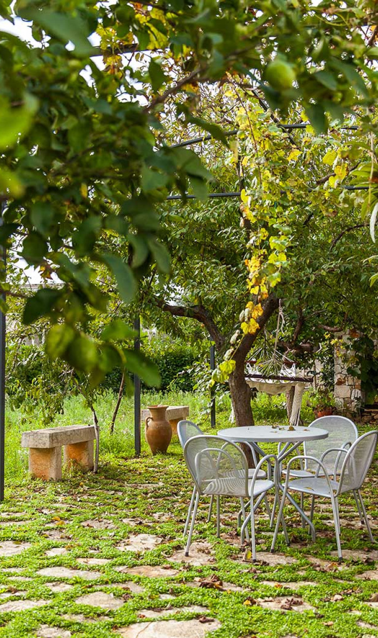 Angolo del Giardino dell'Agriturismo con Tavolini e Sedie